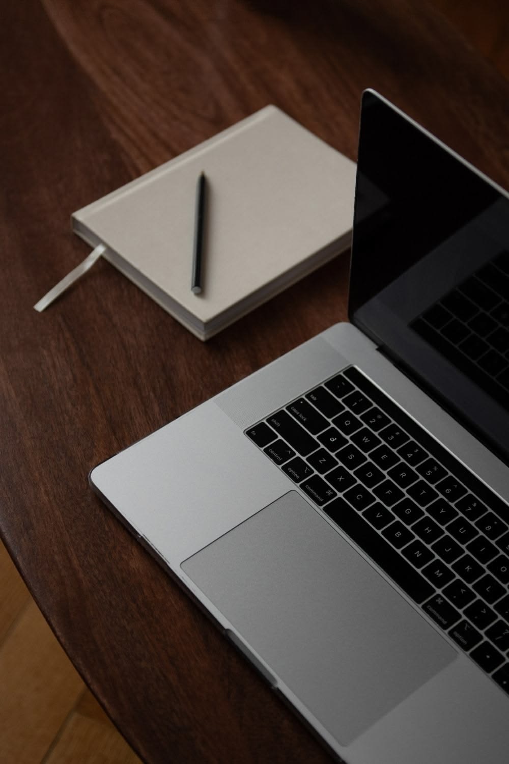 Laptop i notatnik z długopisem na drewnianym biurku